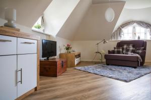 a living room with a couch and a tv at Holiday house, Fuhlendorf in Fuhlendorf