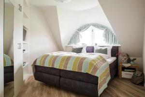 a bedroom with a large bed with an arched window at Holiday house, Fuhlendorf in Fuhlendorf