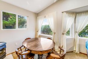 a dining room with a table and chairs and windows at Harvey's Nedonna Nest in Rockaway Beach