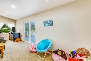a living room with a blue chair and a sign on the wall at Harvey's Nedonna Nest in Rockaway Beach