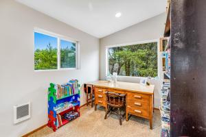 a home office with a desk and two windows at Harvey's Nedonna Nest in Rockaway Beach