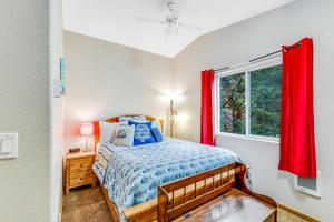een slaapkamer met een bed en een raam met rode gordijnen bij Harvey's Nedonna Nest in Rockaway Beach