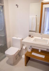 a white bathroom with a toilet and a sink at Cerrado Ville in Alto Paraíso de Goiás +20 photos