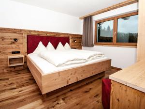 um quarto com uma cama e uma janela em Chalet Freiblick Kleinhaid, Hollersbach em Hollersbach im Pinzgau