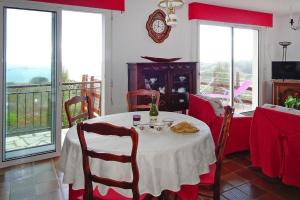 - une salle à manger avec une table, des chaises et des fenêtres dans l'établissement Holiday home with sea views, Trebeurden, à Trébeurden