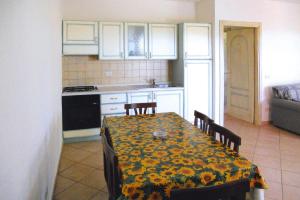 uma cozinha com uma mesa com uma toalha de mesa amarela em Residence La Tartaruga Monte Petruso San Teodoro em San Teodoro
