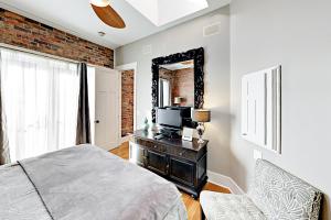 sypialnia z łóżkiem, telewizorem i lustrem w obiekcie The Lofts at Church St w mieście Asheville