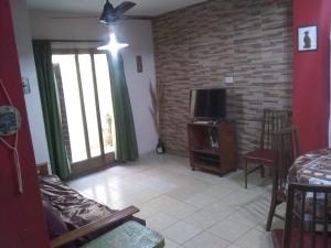 a living room with a couch and a tv at Laura in Rosario +25 photos