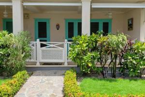 een veranda aan de voorzijde van een huis met groene luiken bij La Dolce Vita Beachfront Apt 2 in Las Terrenas