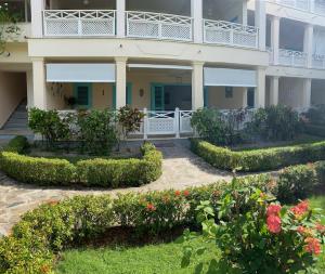 a building with a courtyard with flowers and bushes at La Dolce Vita Beachfront Apt 2 in Las Terrenas