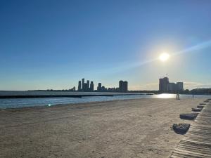 einen Sandstrand mit einer Stadt im Hintergrund in der Unterkunft Home away from home in Toronto