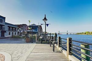 a wooden dock with benches next to a body of water at Water Street Condos II in Wilmington