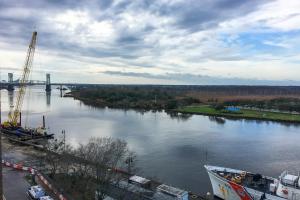 une vue sur une rivière avec une grue et un pont dans l'établissement Water Street Condos II, à Wilmington