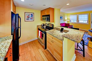 cocina con paredes amarillas, armarios de madera y encimera en Hiawassee W203, en Asheville
