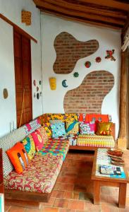 a living room with a couch with colorful pillows at Hotel Casa Canela By MH in Barichara