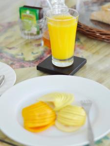a plate of food with a glass of orange juice at hotel boutique lila&co in Tonatico +23 photos