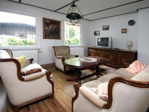 a living room with a table and chairs and a tv at Holiday home Seeidyll, Teupitz in Teupitz