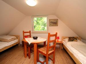 a room with a table and two beds and a window at Holiday home Seeidyll, Teupitz in Teupitz