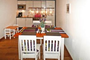 cocina con mesa de comedor y sillas blancas en Apartment Landhaus Markus, Süderschwei en Süderschwei