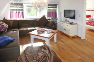 a living room with a couch and a table at Apartment Landhaus Markus, Süderschwei in Süderschwei