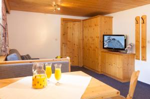 um quarto com uma mesa com dois copos de sumo de laranja em Appartement Jägerhof em Sölden