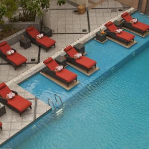 uma vista sobre uma piscina com cadeiras vermelhas em Radisson Blu Hotel, Nagpur em Nagpur