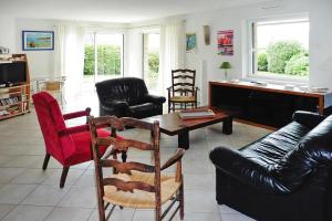 ein Wohnzimmer mit einem Sofa, einem Tisch und Stühlen in der Unterkunft Holiday Home St- Gildas-de-Rhuys - BRE04131-F in Saint-Gildas-de-Rhuys