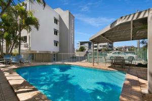 a swimming pool in front of a building at Surfcomber on the Beach in Maroochydore