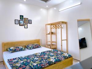 a bedroom with a bed and a mirror at Xoài Xanh Hostel & Villa in Vung Tau