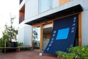 un edificio con una bandera azul delante de él en HOTEL AO KAMAKURA, en Kamakura