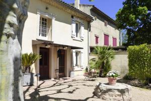 an old house with a courtyard in front of it at Cozy Noves Home with Pool Access in Noves