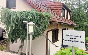 a sign in front of a house with a building at Miniappartement Zini in Lindlar