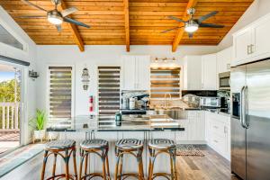 a kitchen with white cabinets and a wooden ceiling at Tradewinds Treat in Big Pine Key