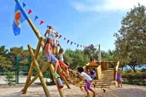 un gruppo di bambini che giocano in un parco giochi di Caravan Park Kovacine, Cres a Cres