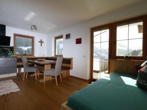 1 dormitorio con 1 cama y comedor con mesa en Holiday flat Schöser, Fügen, en Fügenberg