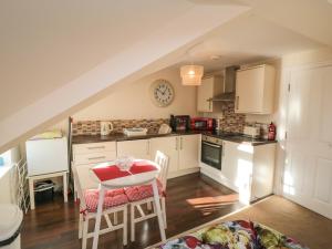 uma cozinha com armários brancos e uma mesa e cadeiras em Carisbrooke House, Apartment 6 em Scarborough