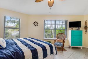 a bedroom with a bed and a tv and a chair at The Anchor House in Marathon +31 photos