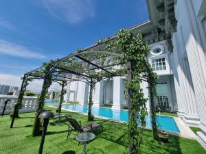a pergola with chairs and a table on a building at Grand Swiss-Belhotel Melaka in Melaka
