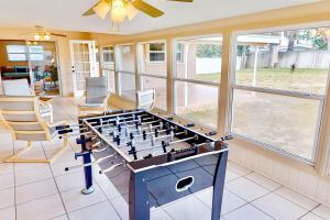 a living room with a foosball table and chairs at Sunlit Serenade in Port Orange