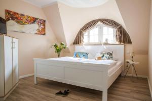 a bedroom with a white bed and a window at Holiday house, Fuhlendorf in Fuhlendorf