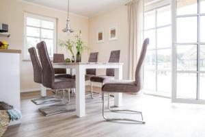 a dining room with a white table and chairs at Holiday house, Fuhlendorf in Fuhlendorf