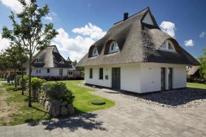 uma casa com telhado de palha e uma entrada em Holiday house, Fuhlendorf em Fuhlendorf