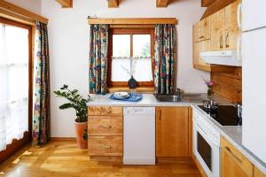 a kitchen with wooden cabinets and a window at Chalet near Kalkalpen National Park in Schlierbach