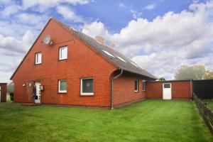 a large red brick house with a large yard at Apartment, Garding in Garding