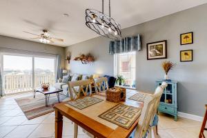 a dining room and living room with a table and chairs at Waterside Village 404 - Sea Dragon in Mexico Beach