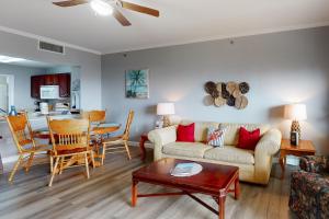 a living room with a couch and a table at Waterside Village 406 - Isle of View More in Mexico Beach