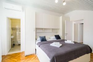 a bedroom with a large bed and a bathroom at House Davor in Slano
