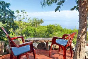 three chairs and a table with a view of the ocean at Finca in El Tanque with a patio in Tanque