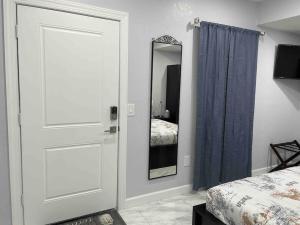 a bedroom with a door and a mirror and a bed at The little Paris suite in Tampa