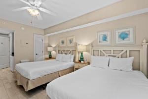a bedroom with two beds and a ceiling fan at Salty Escape in Destin